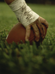 Close-up of the Hand of an American Football Player Holding a Football