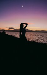 Silhouette of woman at beach with left hand on head photo – ...