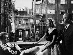 REAR WINDOW, 1954 directed byALFRED HITCHCOCK On the set, Grace Kelly between James Stewart and Alf