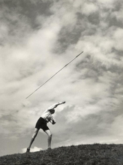 Young Boy Atop a Hill Hurls a Javelin into the Air